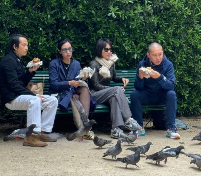 梁朝伟公园吃三文治，脚下有不少白鸽行来行去“陪吃”(图1)